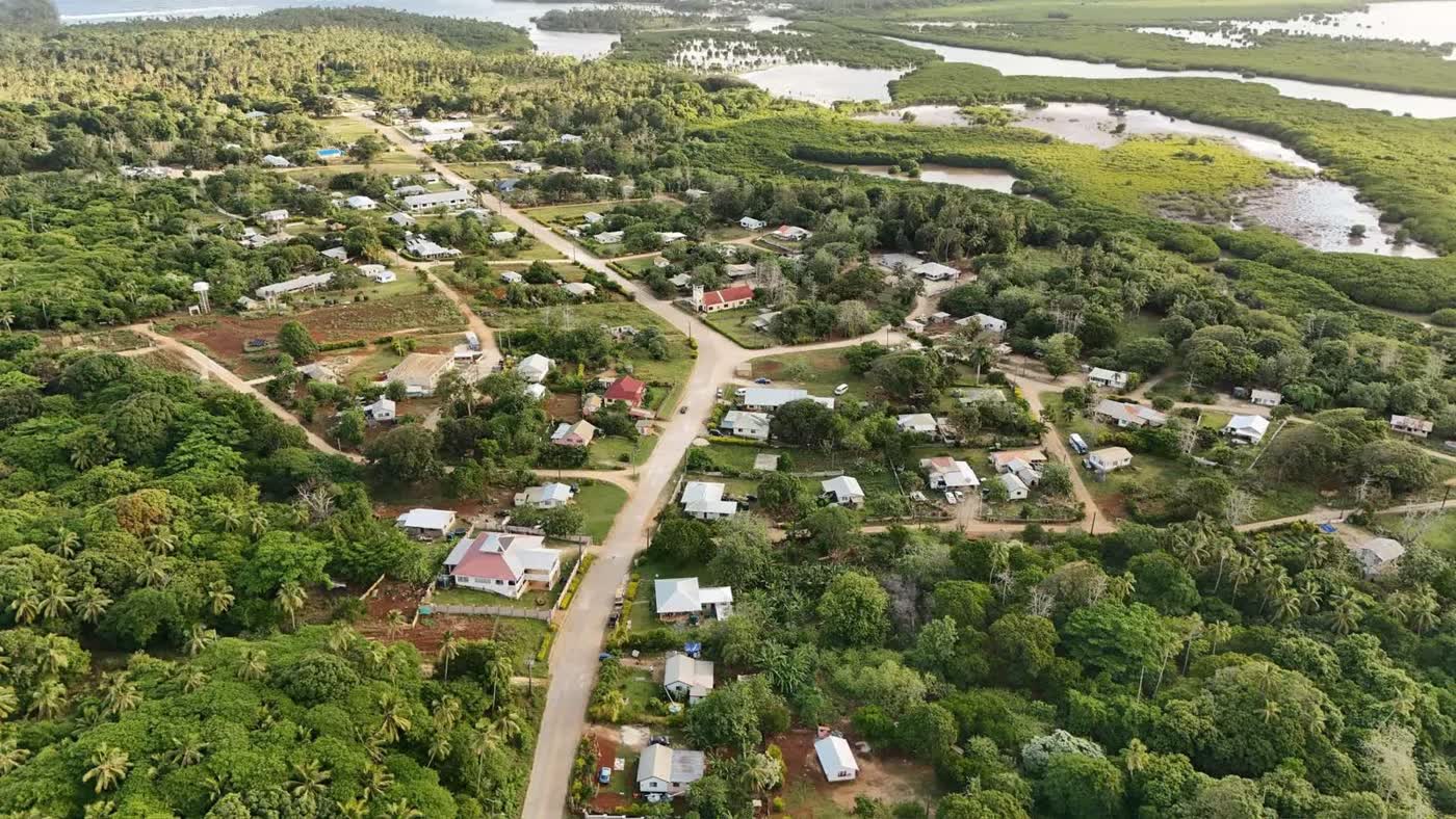 Aerial view of a village in Tonga, with houses on their plots along the roads